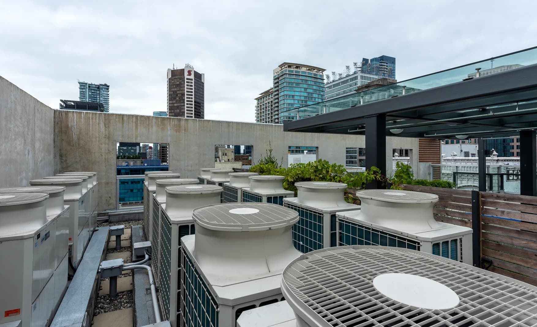 Multiple VRF rooftop HVAC condensing units with rooftop terrace and city skyline in background