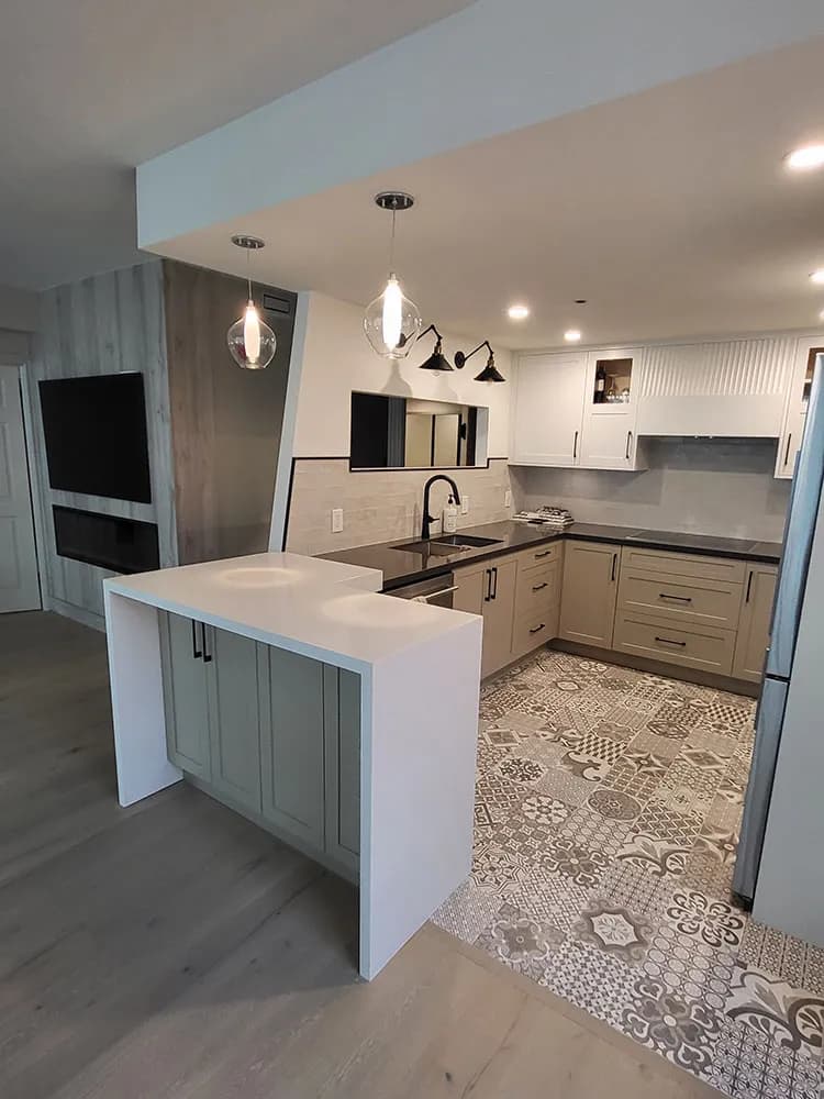 Renovated Toronto kitchen with sage green island, patterned tile floor, white upper cabinets, and pendant lighting